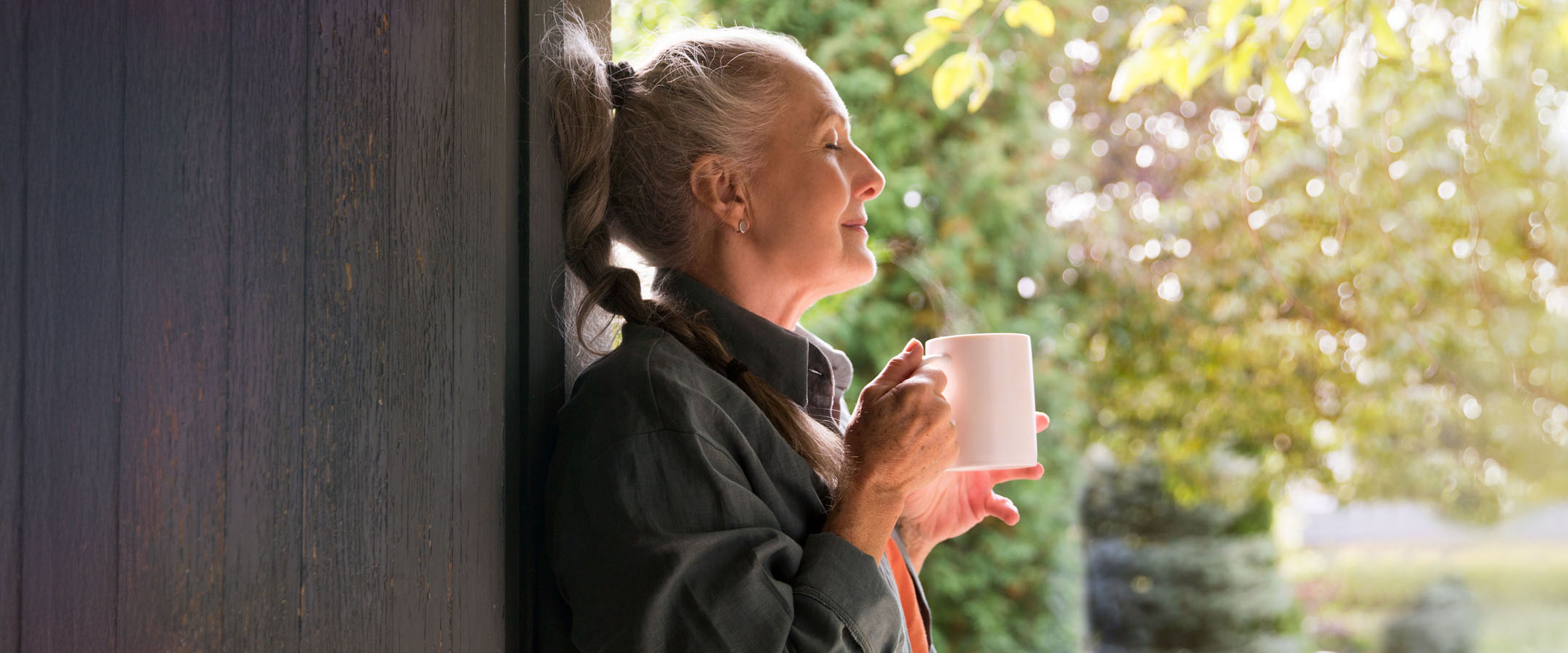 Senior woman enjoying peaceful morning coffee outdoors