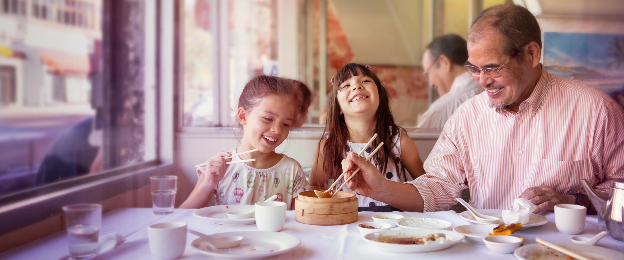Grandfather Sharing Dim Sum With Granddaughters